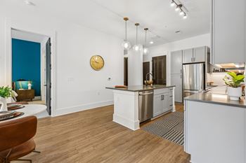 A kitchen with a white island and a clock on the wall.